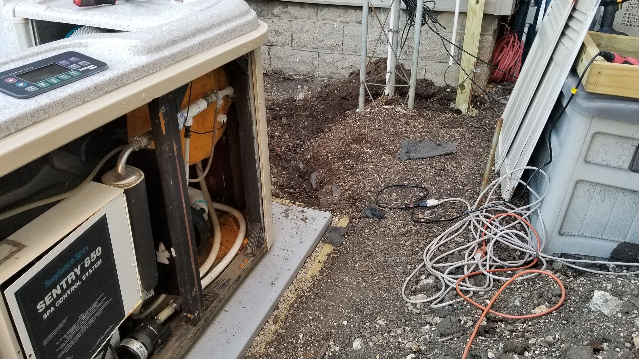 Trench being dug for hot tub electrical conduit